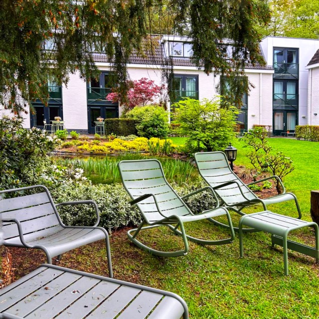 Natuurhotel Witte Berken op de Veluwe: overnachten met kinderen. Er is een groot terras in de tuin, maar ook daarbuiten voldoende plek met ligstoelen en relaxstoelen. Veel tuinmeubels zijn van het duurzame merk Fermob. Wellicht komen de stoelen je bekend voor: ze staan ook in de Parijse Jardin du Luxembourg.